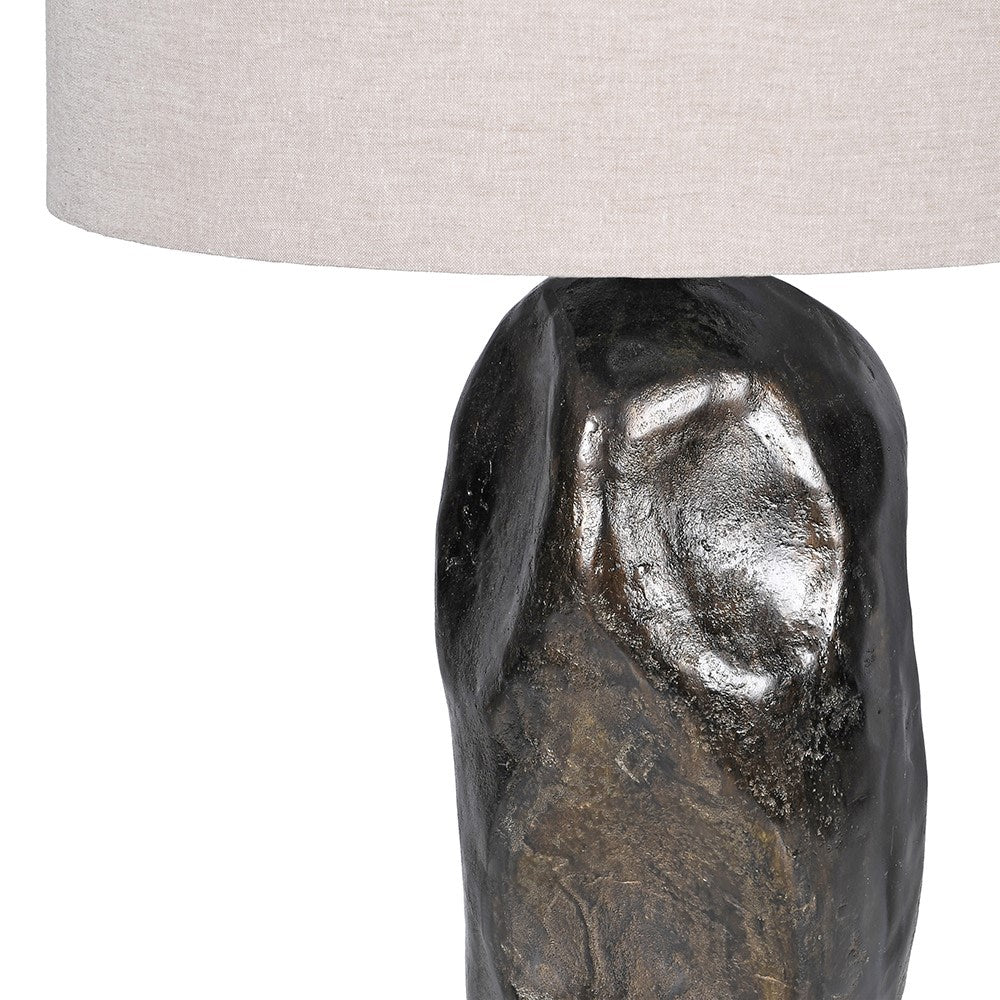Decorative table lamp with a textured base and beige lampshade on a white background