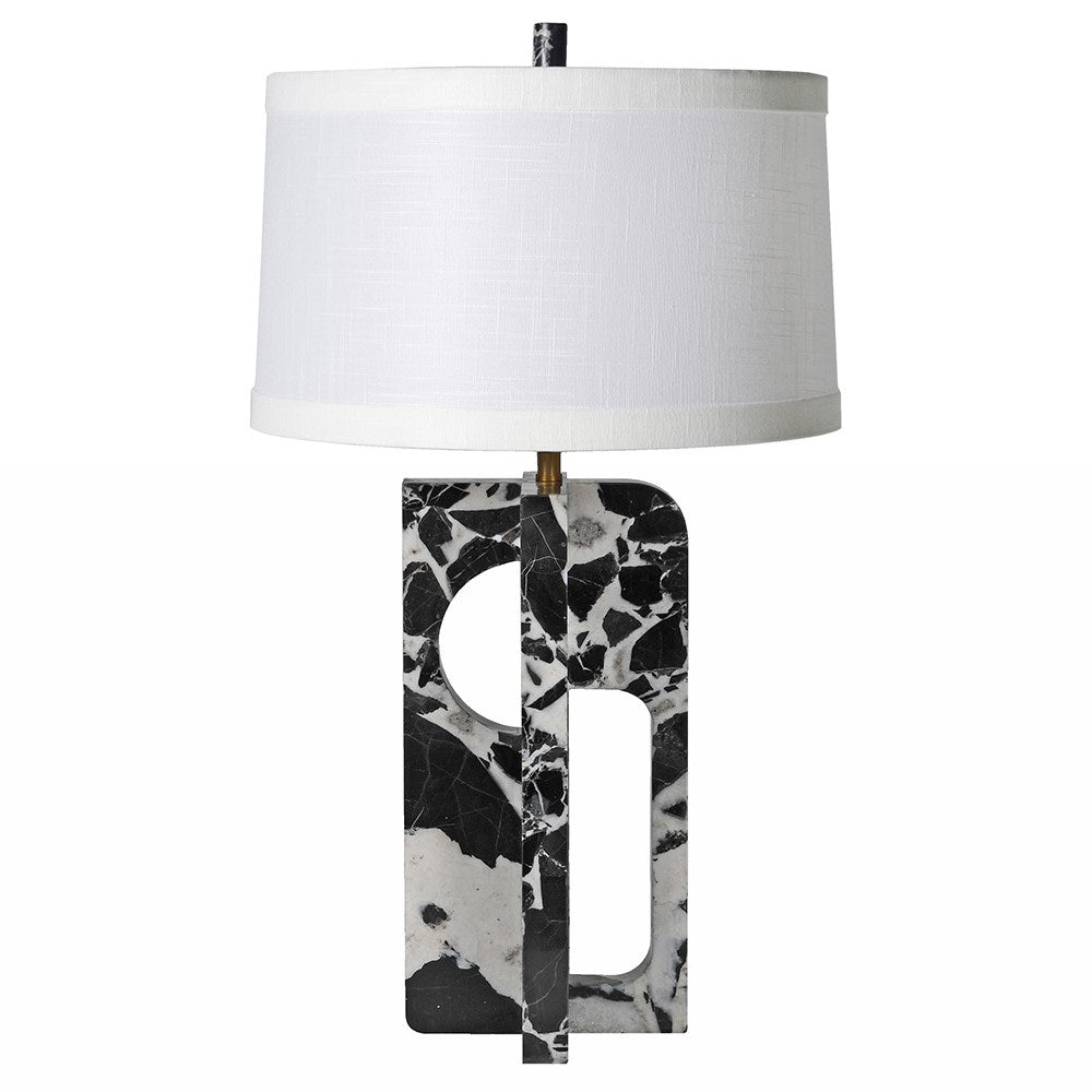 Table lamp with a black and white patterned base and a white shade on a white background