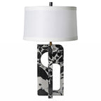 Table lamp with a black and white patterned base and a white shade on a white background